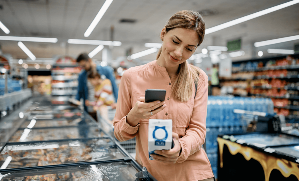smiling woman scanning qr code on a product while