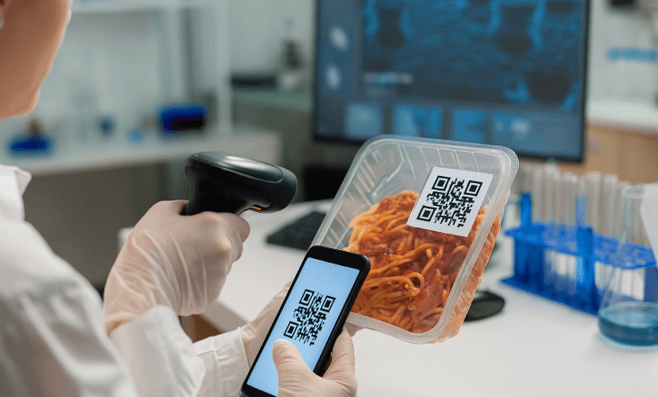A technician in a lab scans a GS1 Digital Link QR code on packaged food to verify compliance and data accuracy.